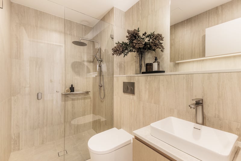 Arte Living Caringbah one bedroom bathroom with walk-in rain shower and stone-look tiles