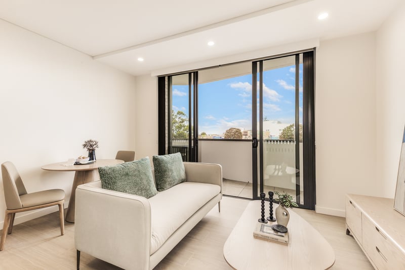 Furnished studio lounge and dining at Arte Living Caringbah opening onto a private balcony