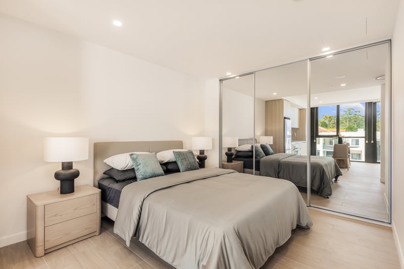 Queen bed and mirrored built-in wardrobe in an Arte Living Caringbah studio
